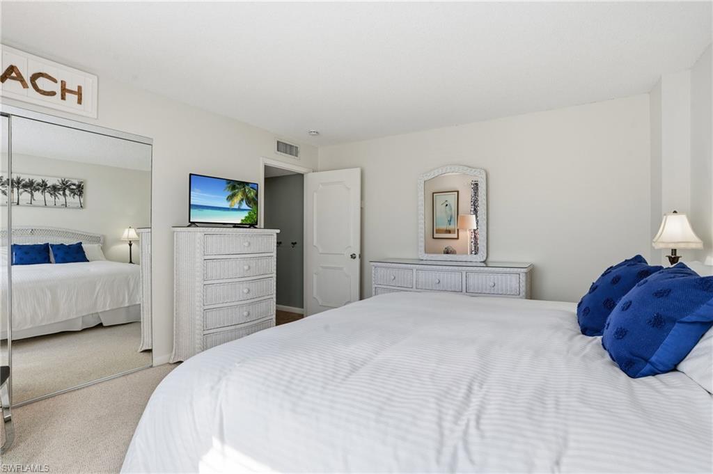 5 Bluebill Avenue, Unit 301 Naples, FL 34108 - Photo 25 of 48 a bedroom with a bed and a couch