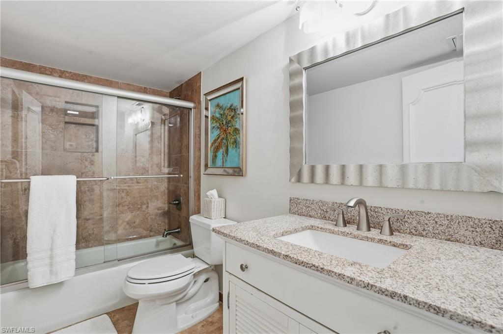 5 Bluebill Avenue, Unit 301 Naples, FL 34108 - Photo 26 of 48 a bathroom with a granite countertop sink toilet and shower