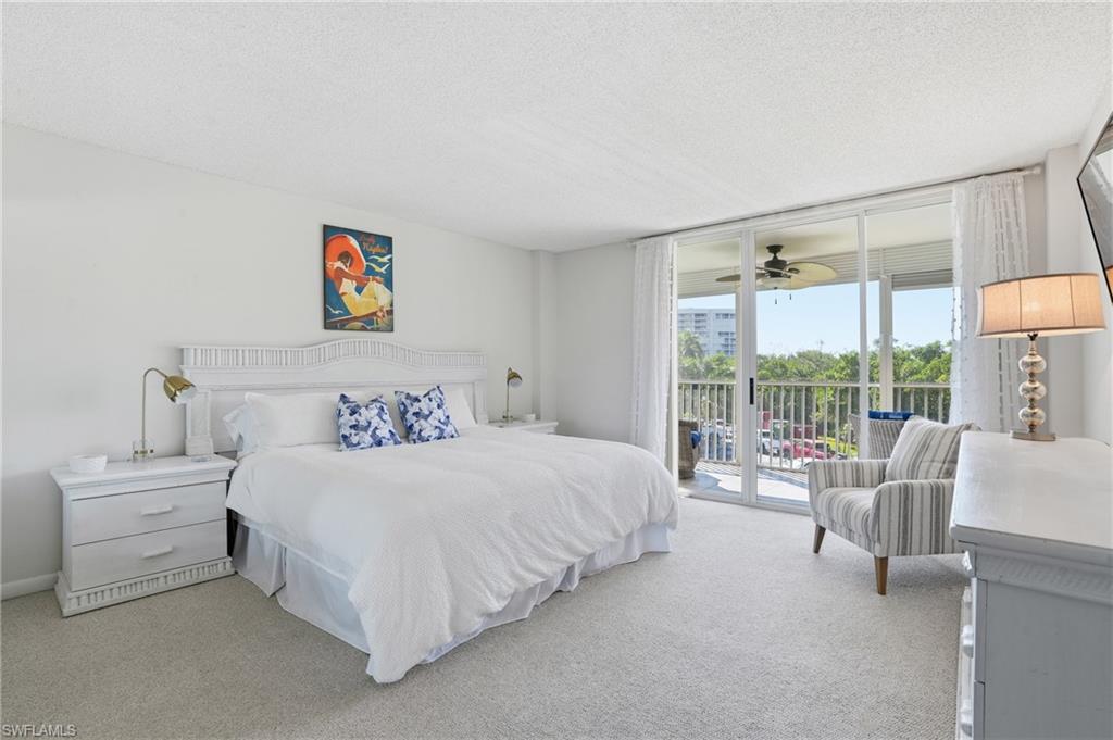 5 Bluebill Avenue, Unit 301 Naples, FL 34108 - Photo 27 of 48 a bedroom with a bed and a large window