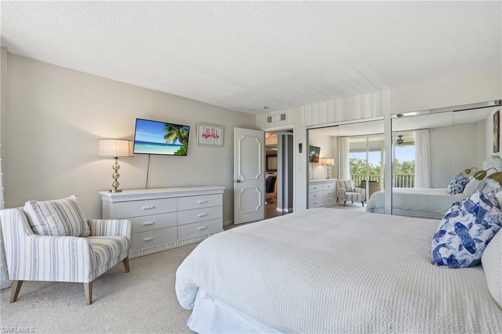 5 Bluebill Avenue, Unit 301 Naples, FL 34108 - Photo 28 of 48 a bedroom with a bed and a couch