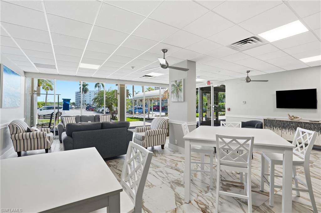 5 Bluebill Avenue, Unit 301 Naples, FL 34108 - Photo 35 of 48 a view of a dining room with furniture large windows and a chandelier
