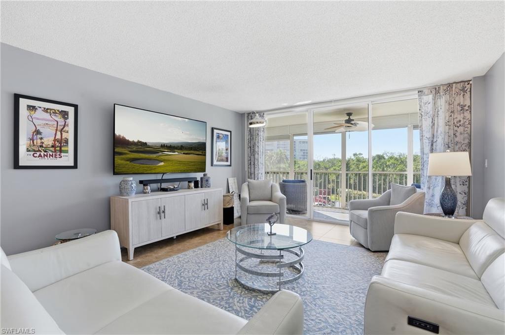 5 Bluebill Avenue, Unit 301 Naples, FL 34108 - Photo 4 of 48 a living room with furniture a large window and a flat screen tv