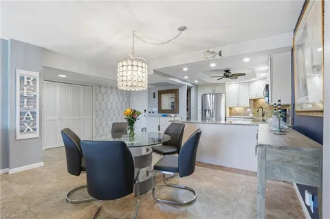 a dining room with furniture a chandelier and wooden floor