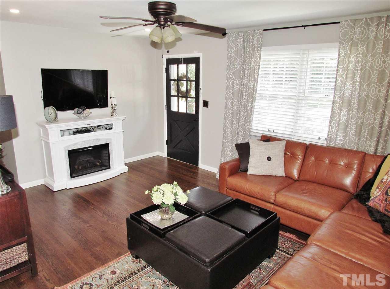 1217 Somerset Road Raleigh, NC 27610 - Photo 3 of 29 a living room with furniture a fireplace and a flat screen tv