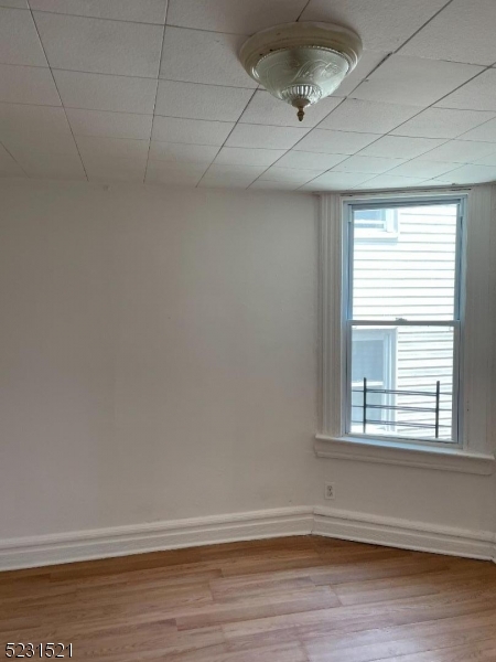 142 Hudson Street, Unit 2 Newark, NJ 07103 - Photo 12 of 13 wooden floor in an empty room with a window
