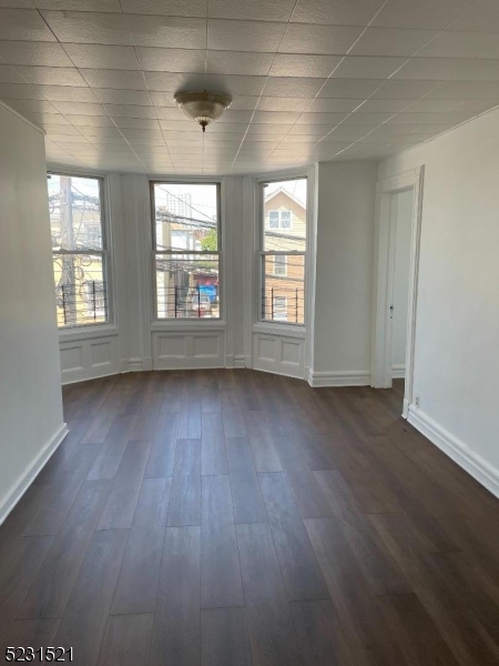 142 Hudson Street, Unit 2 Newark, NJ 07103 - Photo 2 of 13 an empty room with wooden floor and windows