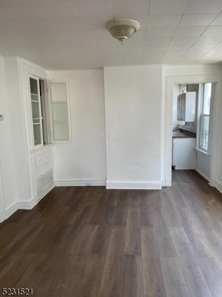 142 Hudson Street, Unit 2 Newark, NJ 07103 - Photo 4 of 13 a view of an empty room with a window and wooden floor