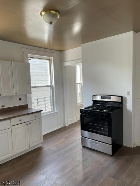 142 Hudson Street, Unit 2 Newark, NJ 07103 - Photo 6 of 13 a kitchen with granite countertop a stove a sink and a window