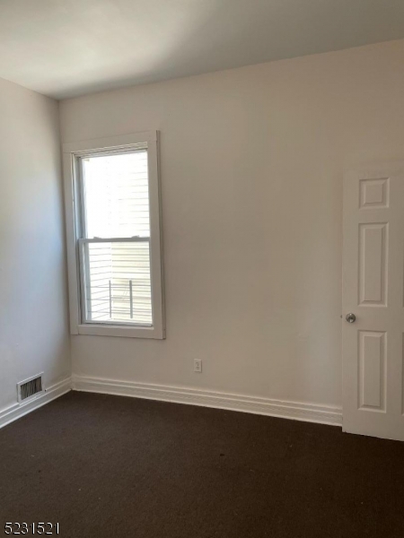 142 Hudson Street, Unit 2 Newark, NJ 07103 - Photo 10 of 13 an empty room with wooden floor and windows