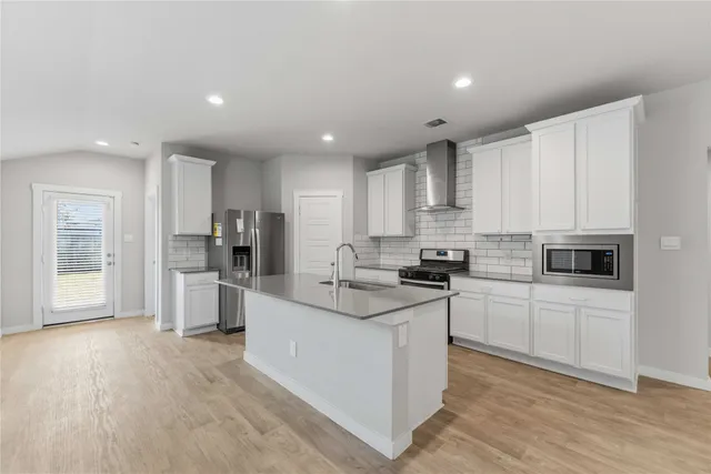 a kitchen with white cabinets and stainless steel appliances