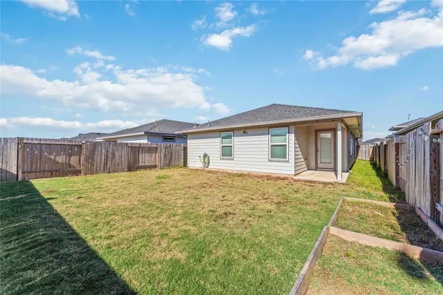 a view of a house with backyard and wooden fence