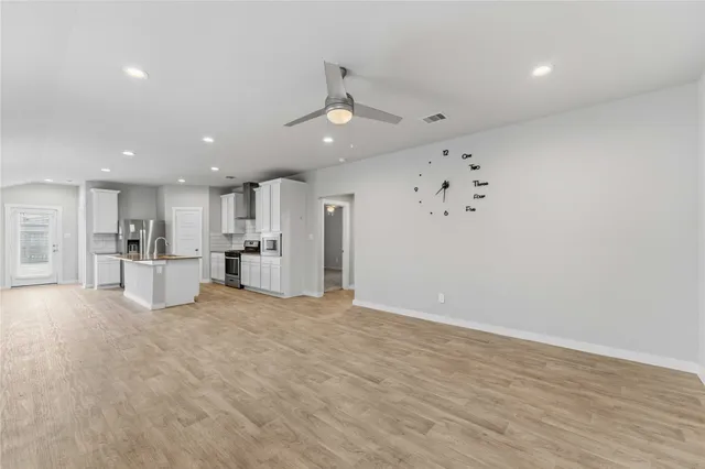 a view of an empty room with kitchen furniture