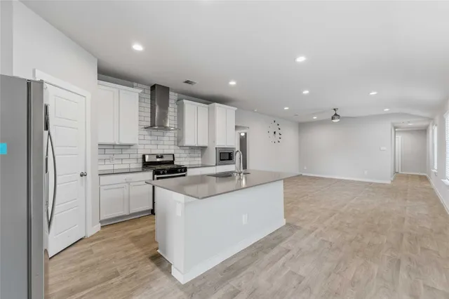 a kitchen with a refrigerator and a stove top oven