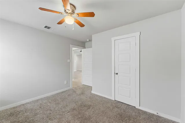 an empty room with chandelier fan