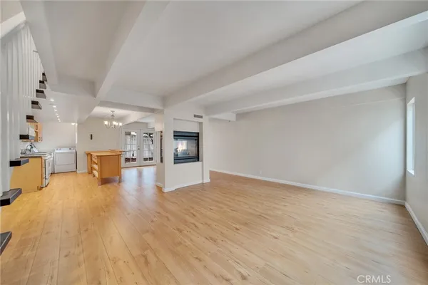 a view of a living room a kitchen with wooden floor and a kitchen