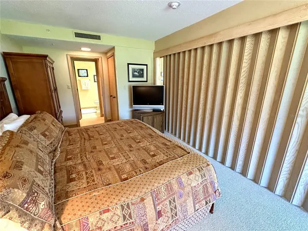a bedroom with a bed and a flat tv screen