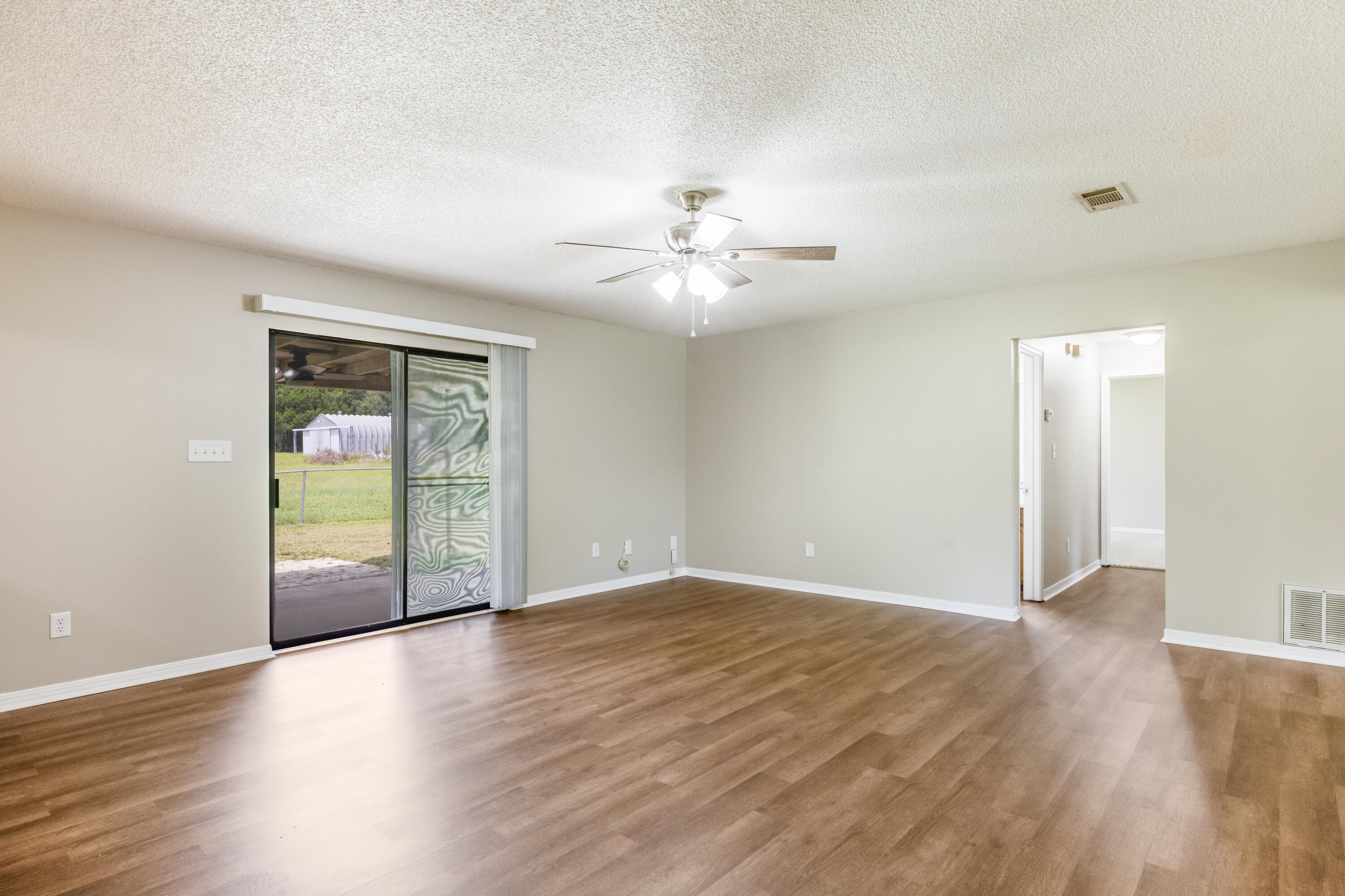 5892 Jack Stokes Road Baker, FL 32531 - Photo 11 of 49 a view of an empty room with window and wooden floor