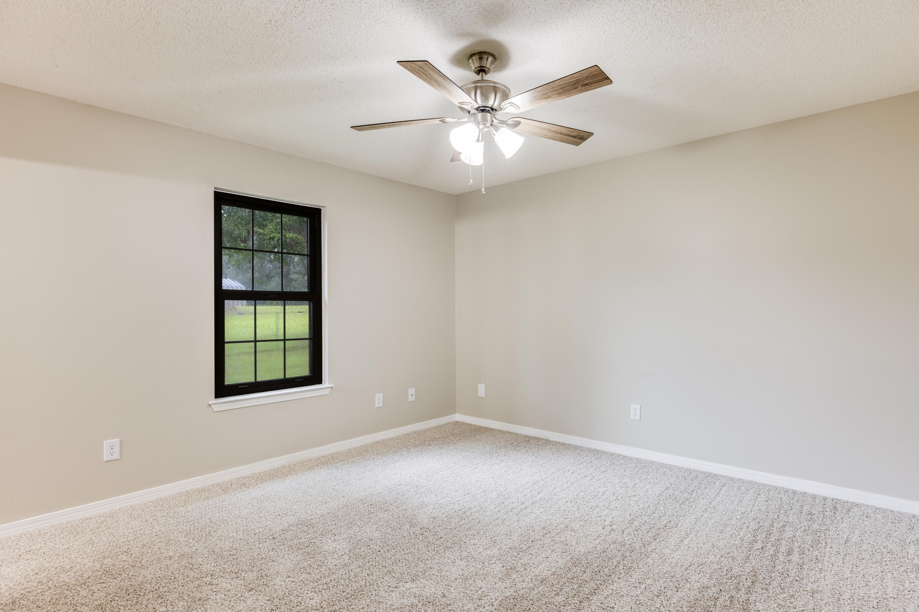 5892 Jack Stokes Road Baker, FL 32531 - Photo 21 of 49 an empty room with windows and fan