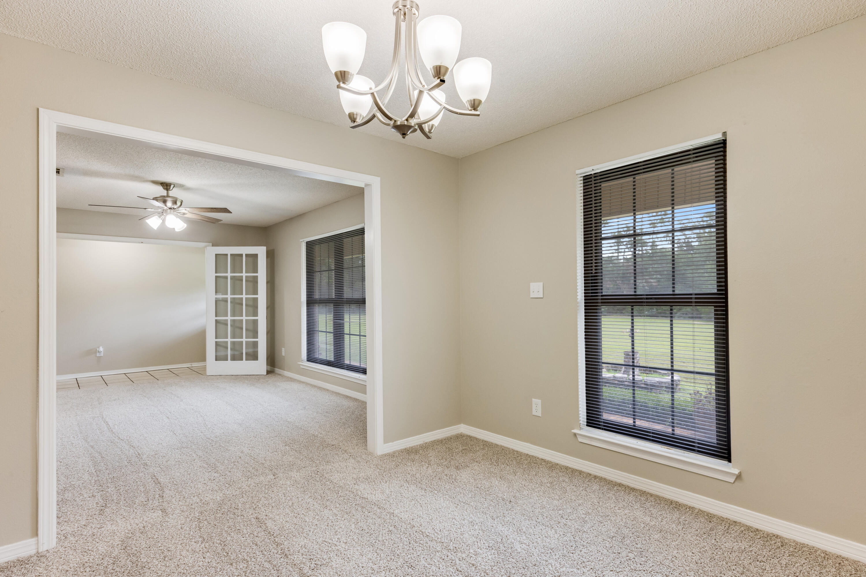 5892 Jack Stokes Road Baker, FL 32531 - Photo 9 of 49 an empty room with chandelier fan and windows