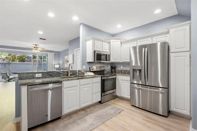 a kitchen with granite countertop stainless steel appliances and wooden cabinets