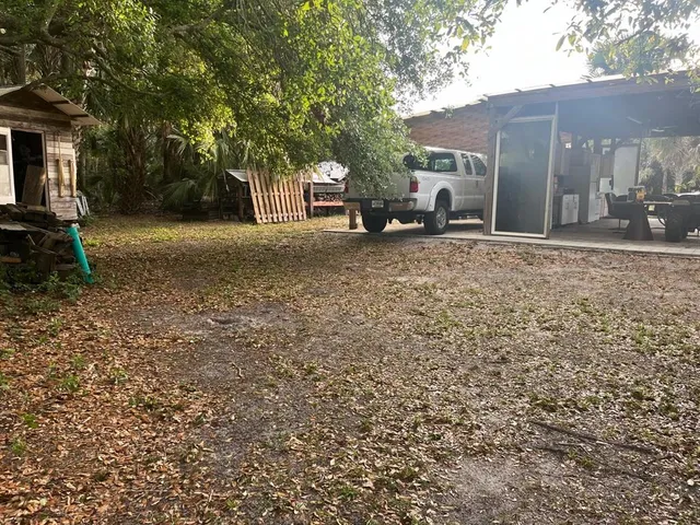 a view of a backyard with table and chairs and a large tree