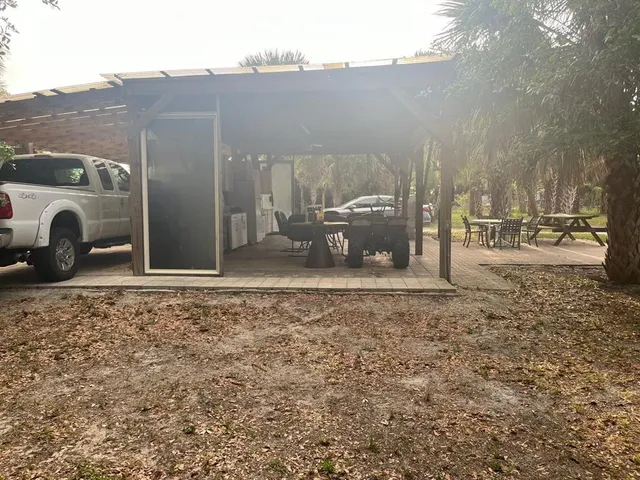 a backyard of a house with barbeque oven table and chairs