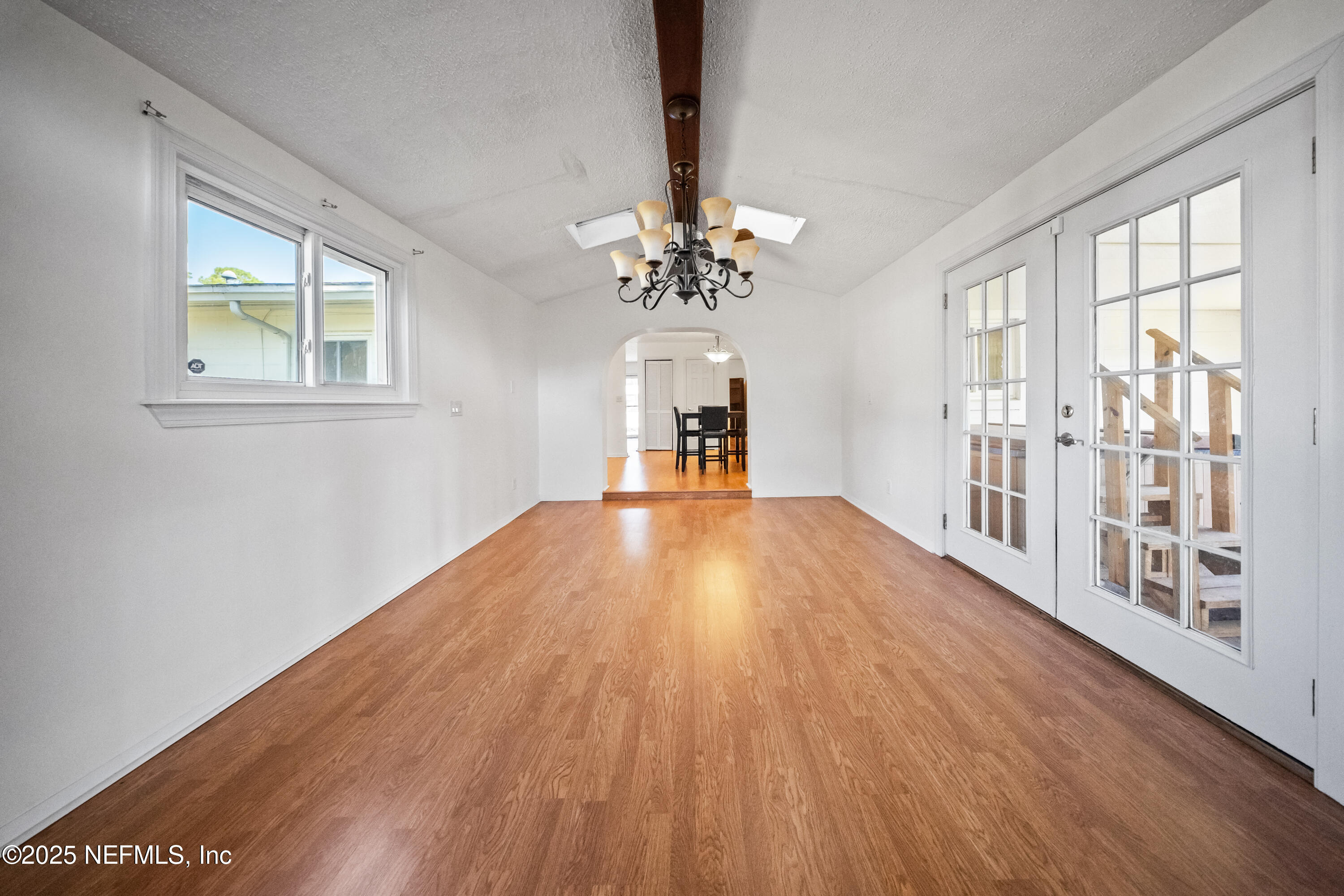 8342 Barracuda Road Jacksonville, FL 32244 - Photo 6 of 20 a big room with wooden floor a chandelier fan and windows