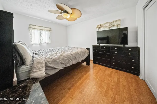 a bedroom with a bed and flat screen tv