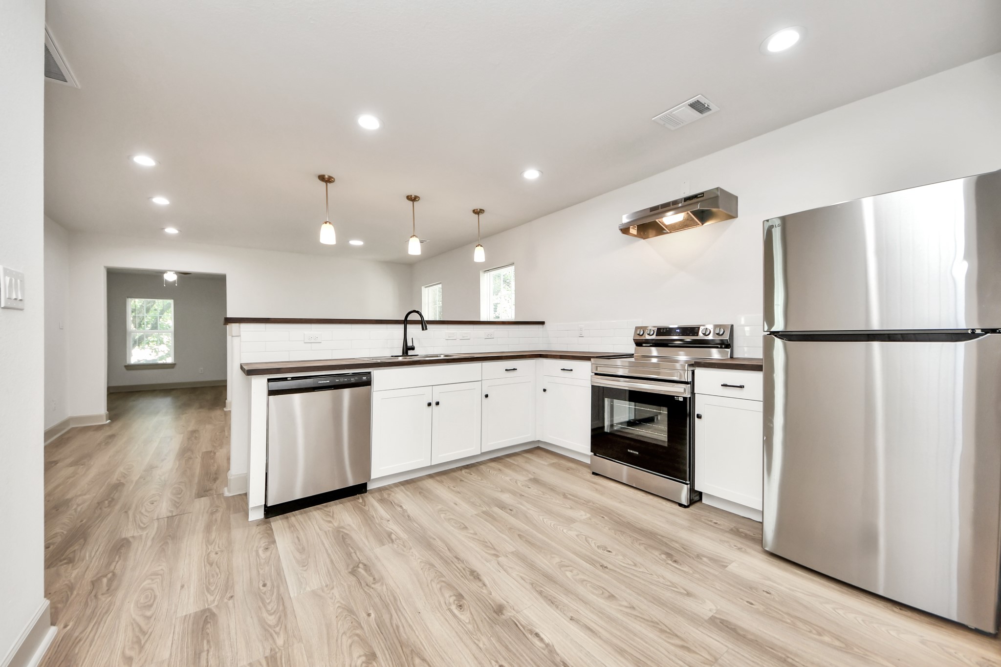 2919 Rosedale Street, Unit B Houston, TX 77004 - Photo 2 of 35 a kitchen with a refrigerator and white cabinets