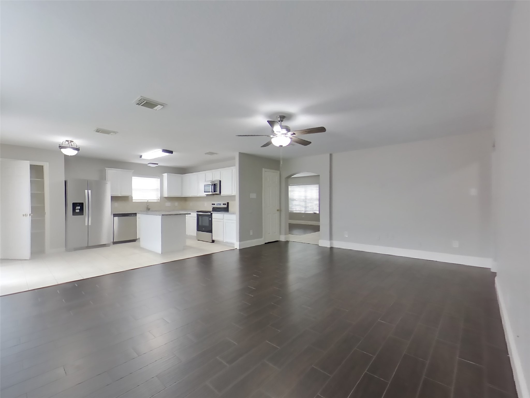 19626 Beachy Court Katy, TX 77449 - Photo 2 of 19 a view of an empty room with wooden floor and a kitchen