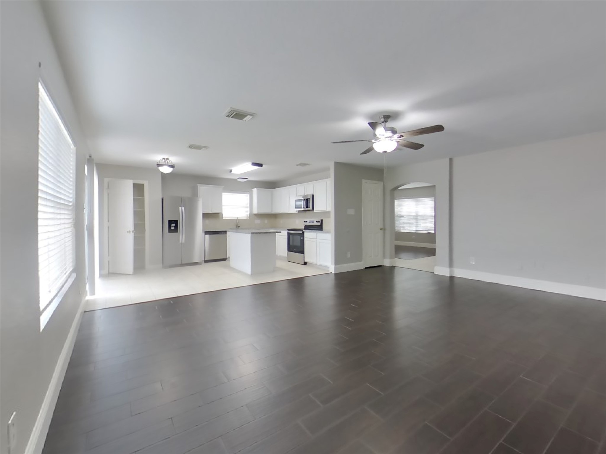 19626 Beachy Court Katy, TX 77449 - Photo 3 of 19 a view of an empty room with a kitchen and wooden floor
