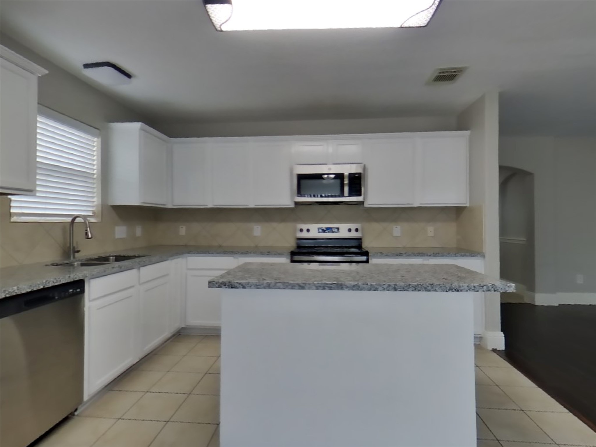19626 Beachy Court Katy, TX 77449 - Photo 6 of 19 a kitchen with stainless steel appliances granite countertop a sink a stove and a microwave