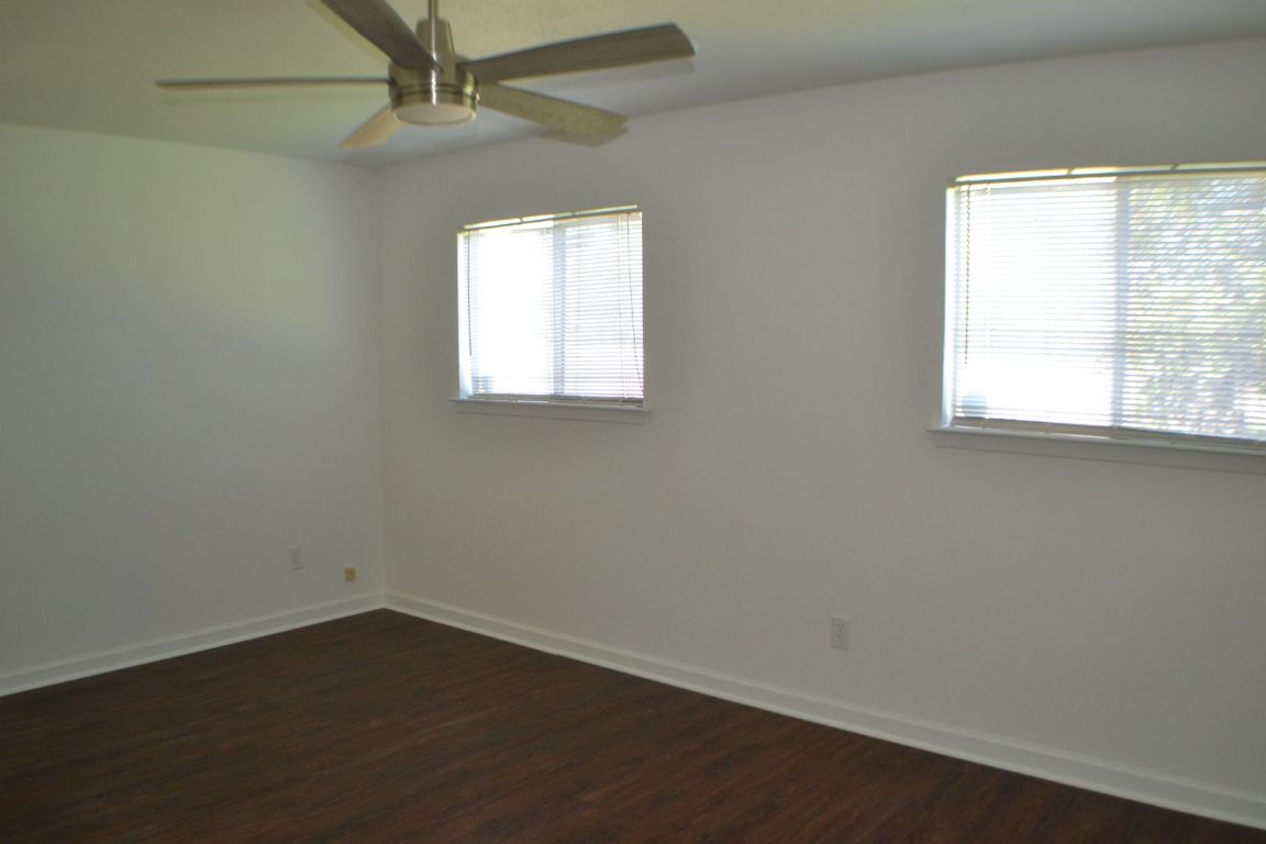4506 Adelphi Lane Austin, TX 78727 - Photo 12 of 13 Empty room featuring dark wood-style floors and ceiling fan