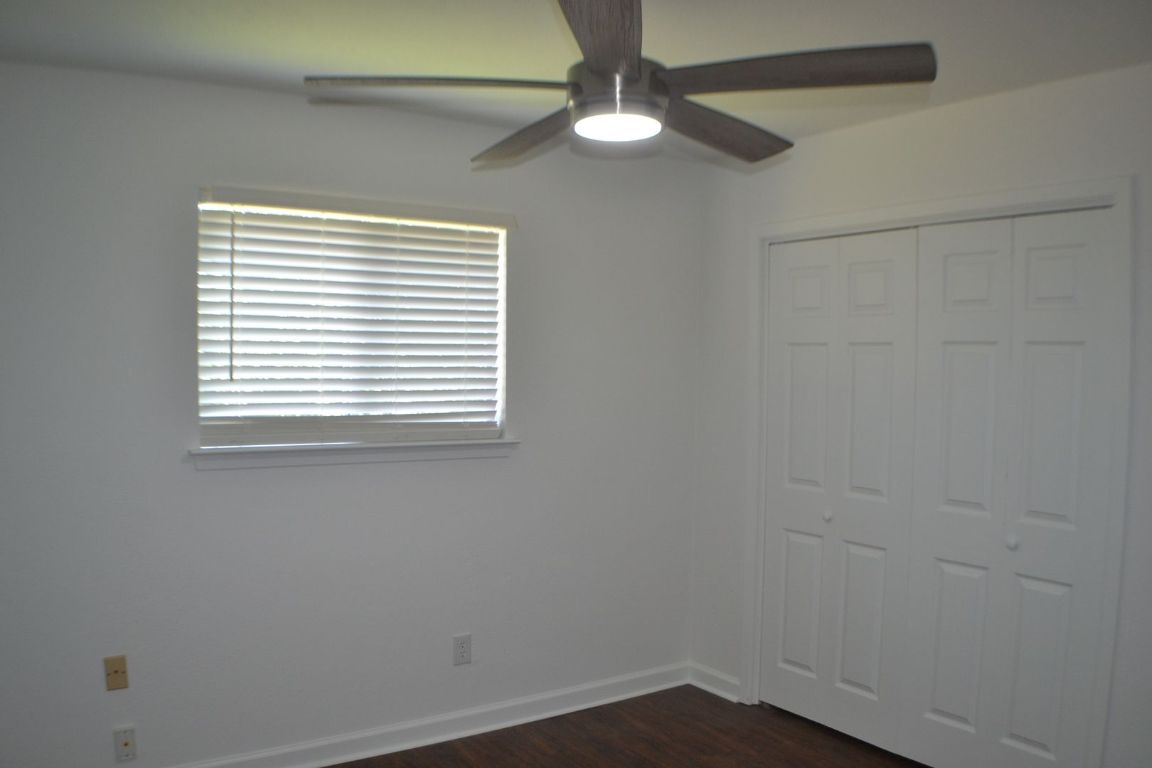 4506 Adelphi Lane Austin, TX 78727 - Photo 7 of 13 Unfurnished bedroom featuring a ceiling fan, dark wood-type flooring, and a closet