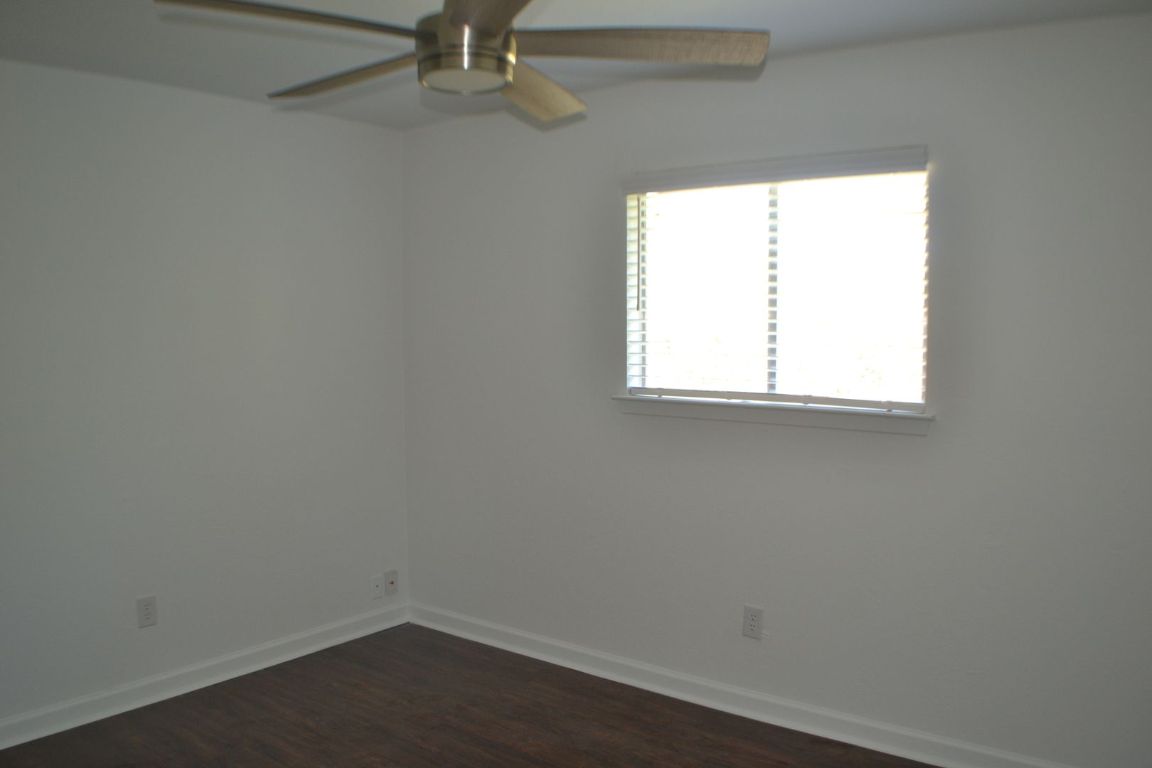 4506 Adelphi Lane Austin, TX 78727 - Photo 10 of 13 Unfurnished room featuring dark wood finished floors and a ceiling fan