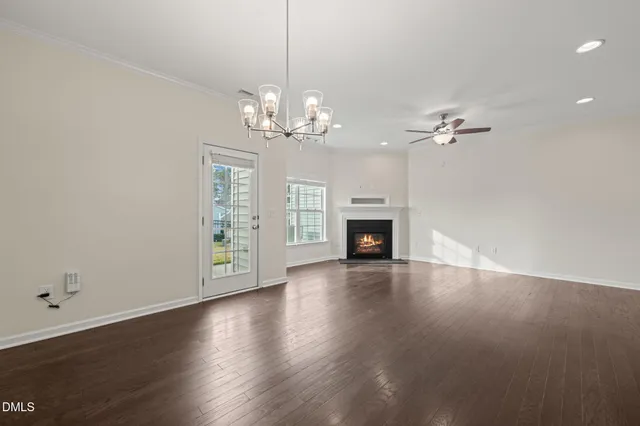 a view of a livingroom with a fireplace a chandelier and wooden floor