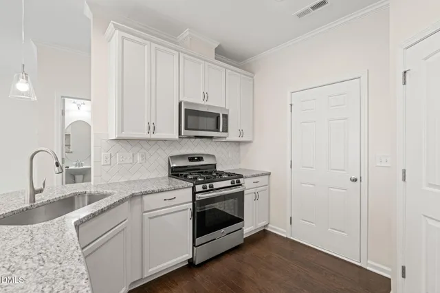 a kitchen with white cabinets and stainless steel appliances