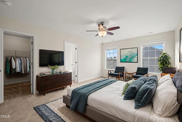 a bedroom with a bed a window and a flat screen television