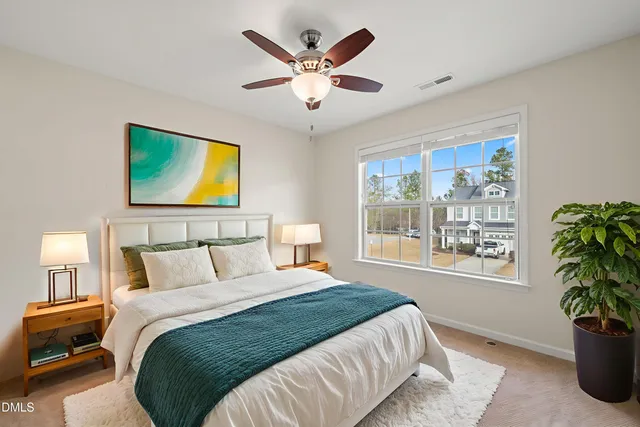 a bedroom with a bed and a potted plant