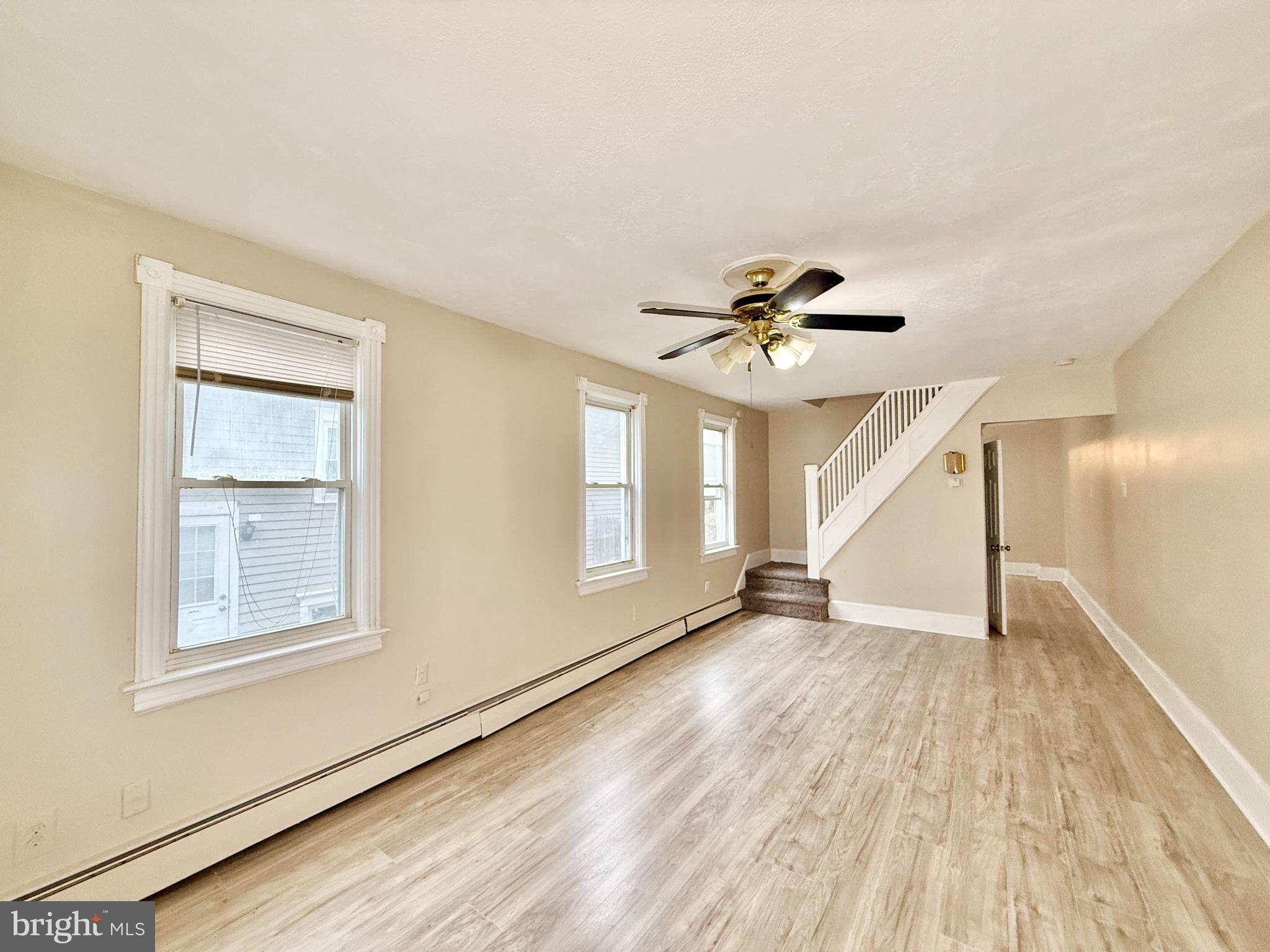 5 Craven Avenue Salem, NJ 08079 - Photo 2 of 13 an empty room with wooden floor chandelier fan and windows