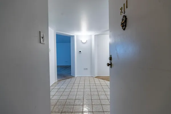 a view of a hallway with a livingroom and refrigerator