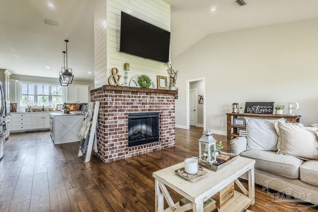 778 Griswold Road Jay, FL 32565 - Photo 16 of 57 a living room with furniture a flat screen tv and a fireplace