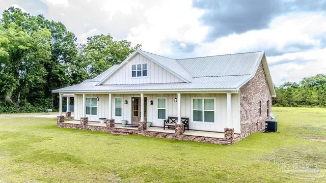 an aerial view of a house with a yard and lake view