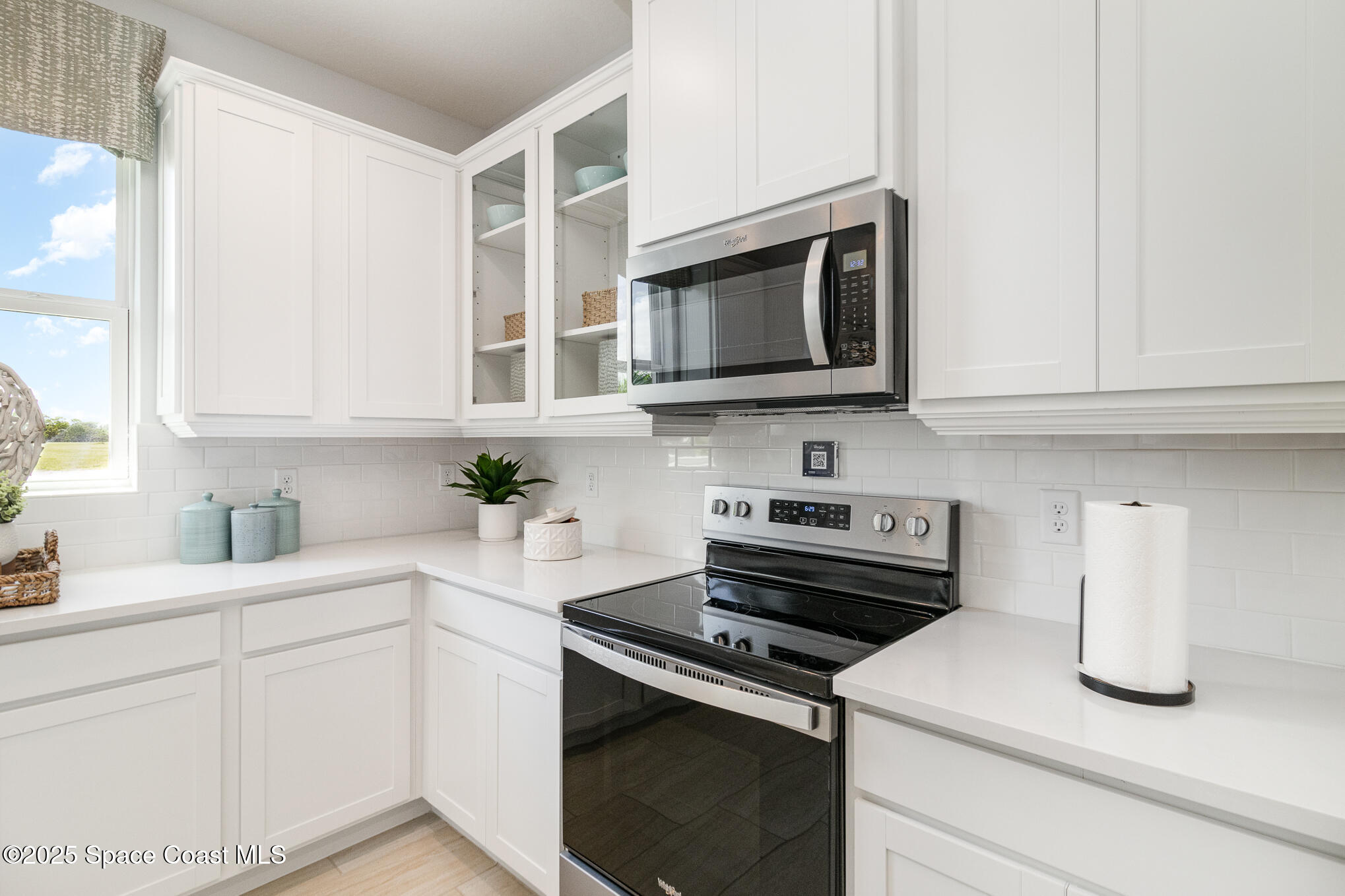 6981 Cameo Drive Grant, FL 32949 - Photo 9 of 48 a kitchen with stainless steel appliances granite countertop white cabinets a stove a microwave and a sink
