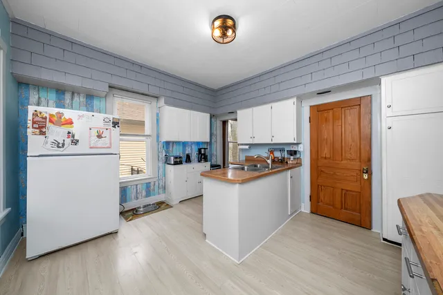 a kitchen with refrigerator and cabinets
