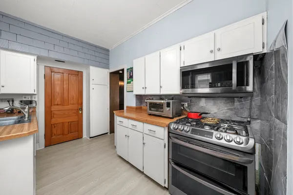 a kitchen with stainless steel appliances a stove a microwave and cabinets
