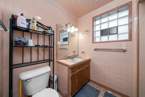 a bathroom with a toilet a sink and a mirror