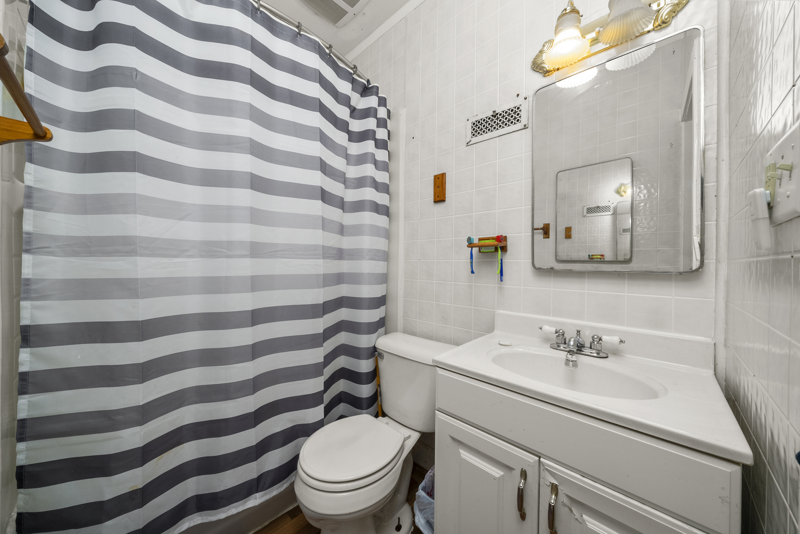 516 Catherine Street Ottawa, IL 61350 - Photo 27 of 38 a bathroom with a sink a toilet a mirror and shower curtain