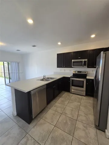 a kitchen with stainless steel appliances granite countertop a refrigerator and a stove top oven