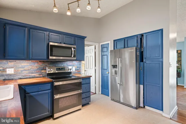 a kitchen with stainless steel appliances granite countertop a sink stove microwave and wooden cabinets